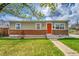 Attractive home featuring a brick foundation, well-kept lawn, and bright red front door for added curb appeal at 2850 Roosevelt, Thornton, CO 80229