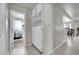 A hallway with a white built in, view of a bathroom with a shower, and light wood floors at 2850 Roosevelt, Thornton, CO 80229