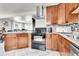 A kitchen with stainless steel appliances, wood cabinets, and stone countertops, and backsplash at 2850 Roosevelt, Thornton, CO 80229