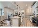 Bright kitchen features white cabinets, an island with pendant lighting, and stainless steel appliances at 11905 Sea Oats St, Parker, CO 80138