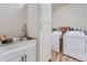 Bright laundry room with wood-look floors, sink, cabinets and washer/dryer at 11905 Sea Oats St, Parker, CO 80138