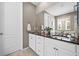 Elegant bathroom featuring double vanity sinks with a large mirror and tile flooring at 827 Sundance Ln, Erie, CO 80516