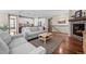 Bright living room featuring hardwood floors, an adjacent kitchen, and a stone fireplace at 827 Sundance Ln, Erie, CO 80516