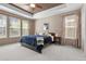 Relaxing main bedroom featuring a tray ceiling, carpeted floors, and lots of natural light at 827 Sundance Ln, Erie, CO 80516
