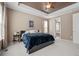 Bright main bedroom featuring a tray ceiling, carpeted floors, and an ensuite bathroom at 827 Sundance Ln, Erie, CO 80516