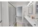 Bright bathroom featuring a glass shower door and modern vanity with double sinks and neutral color palette at 8008 W Spanish Peak, Littleton, CO 80127