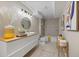 Modern bathroom with sleek white vanity, unique round mirror, and shower-tub combination at 19061 Eagle Ridge Dr, Golden, CO 80401