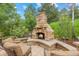Outdoor stone fireplace with built in seating, ideal for gatherings and enjoying the serenity of the backyard at 19061 Eagle Ridge Dr, Golden, CO 80401