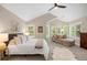 Bright main bedroom featuring vaulted ceilings, a sitting area and a king bed with a faux fur rug at 19061 Eagle Ridge Dr, Golden, CO 80401