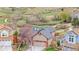 Aerial view of a home with blooming trees, a fenced yard, and a well-maintained roof at 7507 Halleys Dr, Littleton, CO 80125