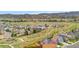 Wide aerial view of the neighborhood with green spaces and mountain range in the background at 7507 Halleys Dr, Littleton, CO 80125