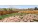 Large stone back patio with wood fence and landscaping, perfect for entertaining guests at 7507 Halleys Dr, Littleton, CO 80125