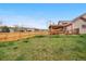 Spacious backyard featuring a wooden fence, green lawn, and a covered deck for outdoor living at 7507 Halleys Dr, Littleton, CO 80125