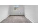 Minimalist bedroom featuring neutral carpet, white walls, and a single window allowing natural light at 7507 Halleys Dr, Littleton, CO 80125