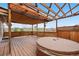 Inviting covered deck featuring a hot tub, lattice ceiling, and scenic backyard views at 7507 Halleys Dr, Littleton, CO 80125