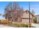 Charming exterior of a home showcasing brick and siding, a blooming tree, and a two-car garage at 7507 Halleys Dr, Littleton, CO 80125