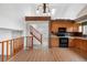 Open kitchen with wood cabinets, black appliances, brick features, and high, vaulted ceilings at 7507 Halleys Dr, Littleton, CO 80125