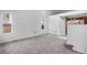 A sunny living room with carpet flooring, high ceilings, and an opening leading to the kitchen at 7507 Halleys Dr, Littleton, CO 80125
