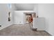 Sun-lit living room featuring vaulted ceilings, carpet floors, and access to a second story at 7507 Halleys Dr, Littleton, CO 80125