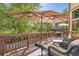Outdoor deck featuring comfortable seating, an umbrella for shade, and a view of lush greenery at 10703 Flagler Dr, Parker, CO 80134