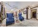 Elegant living room with plush seating, decorative pillars, and a view towards the dining area and stairway at 10703 Flagler Dr, Parker, CO 80134