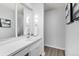 A bright bathroom with a large vanity mirror, white cabinets, and modern lighting and fixtures at 2835 S Monaco Pkwy # 4-103, Denver, CO 80222