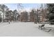 Apartment complex exterior covered in snow, surrounded by bare trees and park benches at 2835 S Monaco Pkwy # 4-103, Denver, CO 80222