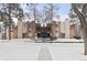 Apartment building exterior with brick accents, balconies, and snow-covered grounds and bare trees at 2835 S Monaco Pkwy # 4-103, Denver, CO 80222