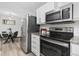 Updated kitchen featuring stainless steel appliances, stylish white cabinets, and an adjacent dining area for convenience at 2835 S Monaco Pkwy # 4-103, Denver, CO 80222