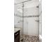 Walk-in shower with pebble floor and glass enclosure at 9167 E 35Th Ave, Denver, CO 80238