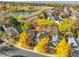 Aerial view of homes near a serene lake and golf course, surrounded by colorful fall foliage at 10971 Bryant St, Westminster, CO 80234