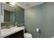 Well-lit bathroom with a dark wood vanity, toilet, and a decorative mirror at 10971 Bryant St, Westminster, CO 80234