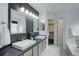 Modern bathroom with dual sinks, a walk-in closet, and a separate tub area at 10971 Bryant St, Westminster, CO 80234