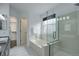 Bright bathroom with tile floor, glass shower, soaking tub and closet access at 10971 Bryant St, Westminster, CO 80234