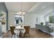 Elegant dining area featuring a modern chandelier, stylish furniture, and hardwood floors, adjacent to a living space at 10971 Bryant St, Westminster, CO 80234