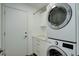 Functional laundry room with stackable washer and dryer, cabinets, and storage space at 10971 Bryant St, Westminster, CO 80234