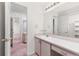 Bathroom with pink vanity, large mirror and access to bedroom at 6017 Thunder Hill Rd, Parker, CO 80134