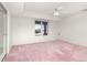 Spacious bedroom with pink carpet, ceiling fan and window views at 6017 Thunder Hill Rd, Parker, CO 80134