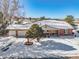 Brick ranch home with attached two-car garage and snowy front yard at 6017 Thunder Hill Rd, Parker, CO 80134