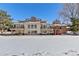 Two-story home with large deck and snowy backyard, surrounded by trees at 6017 Thunder Hill Rd, Parker, CO 80134
