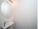 Clean half-bathroom features a sink, faucet and round mirror at 13585 E 103Rd Pl, Commerce City, CO 80022