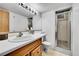 Bathroom includes a shower with glass doors, a white sink and vanity, and a large mirror at 7861 Osceola St, Westminster, CO 80030