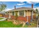 Side view of brick house with manicured lawn, stone border, and chimney at 7861 Osceola St, Westminster, CO 80030