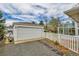 Detached garage with a spacious driveway and white picket fence offering ample parking and a classic aesthetic at 7861 Osceola St, Westminster, CO 80030
