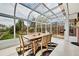 Sunroom with glass roof, dining table, and views of the well maintained backyard at 7861 Osceola St, Westminster, CO 80030