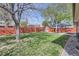 Lush backyard featuring a red shed, mature trees, green grass and a wooden fence at 10731 Rosalie Dr, Northglenn, CO 80233