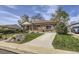 Charming brick home featuring a long driveway, manicured lawn, and mature landscaping at 10731 Rosalie Dr, Northglenn, CO 80233