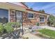 Charming brick home showcasing front entrance with black security door and manicured landscaping at 10731 Rosalie Dr, Northglenn, CO 80233