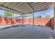 Covered patio featuring concrete flooring, metal framework, and a red wooden fence at 10731 Rosalie Dr, Northglenn, CO 80233