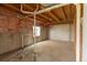 Unfinished basement with concrete walls and exposed ceiling and pipes at 116 Willowleaf Dr, Littleton, CO 80127